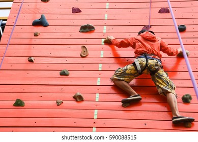 Sporty man practicing rock climbing in climbing gym. - Powered by Shutterstock