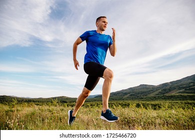 sporty man runner running on mountain plateau in summer