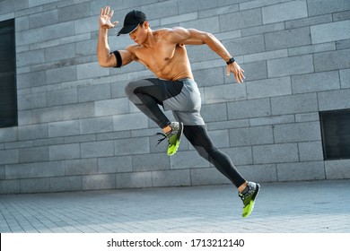 Sporty Man Running. Side View Of Active Man Training In The City. Dynamic Movement. Sports And Healthy Lifestyle