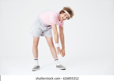 Sporty Man Stretching Back And Leg Muscles Looking Straight 