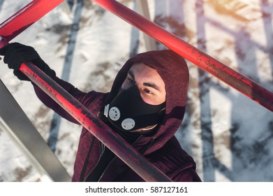 Sporty Man In Training Mask Doing Pull Ups Exercise On Bars Outdoors. Winter Fitness Activity