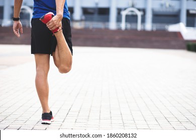 Sporty man Wearing a blue shirt .stretching exercise for warming up before running in the park or gym workout. Fitness and healthy lifestyle concept. - Powered by Shutterstock