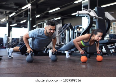 Sporty Man And Woman Doing Push-up In A Gym.