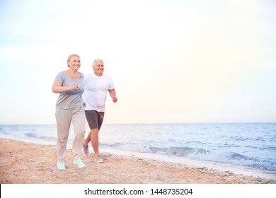 Sporty Mature Couple Running On Sea Beach