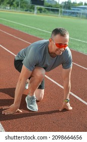 Sporty Mature Man Getting Ready To Run At Stadium