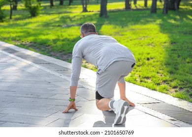 Sporty Mature Man Getting Ready To Run In Park