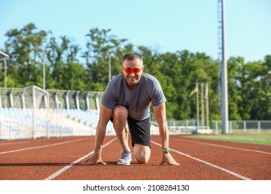 Sporty Mature Man Getting Ready To Run At Stadium