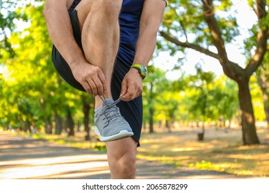 Sporty Mature Man Tying Shoe Laces In Park, Closeup