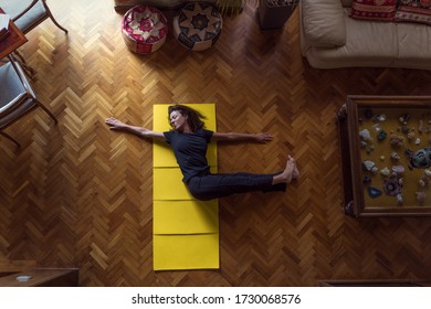 Sporty Mature Woman Doing Yoga At Home In A Yellow Mat.