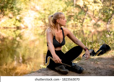 Sporty Mid Aged Woman Sitting By The Lake Relaxing And Practice Breathing Exercise. Attractive Adult Female Meditate In Quiet Nature