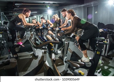 Sporty People Riding Indoor Bicycles On Cycling Class In The Gym.