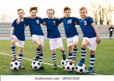 Sporty School Boys in Soccer Team. Group of Children in Football Jersey Sportswear Standing with Balls on Grass Pitch. Happy Smiling Kids in Sport Team - Powered by Shutterstock