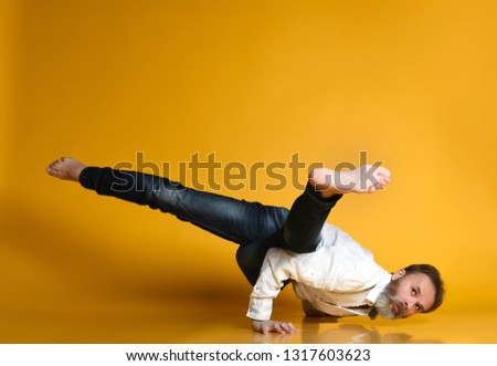 Similar – Man practicing yoga, handstand against a yellow wall