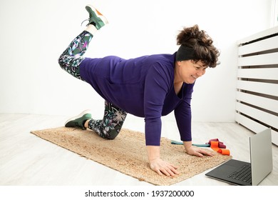 Sporty Senior Woman Doing Online Exercise Class With Laptop At Home