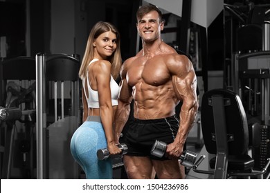 Sporty Sexy Couple Showing Muscle And Workout In Gym. Muscular Man And Woman