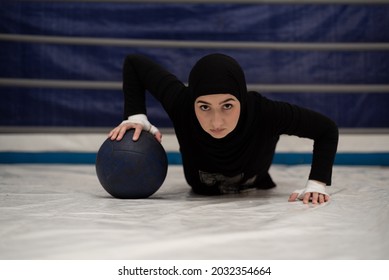 Sporty Strong Woman In Hijab Doing Push-ups On Medical Ball. Female Boxer Exercise. 