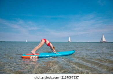 Sporty Teen Girl Practising Yoga And On Sup Or Paddle Board