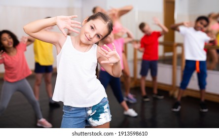 Sporty Ten Years Old Girl Training Movements Of Vigorous Dance During Group Class In Dance School..