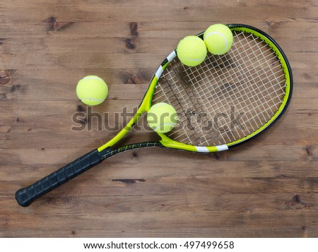Sporty tennis racket with balls on wooden table