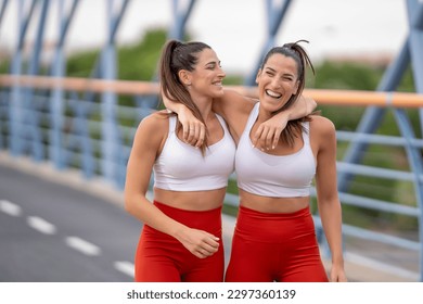 Sporty twin sisters embracing smiling - Powered by Shutterstock