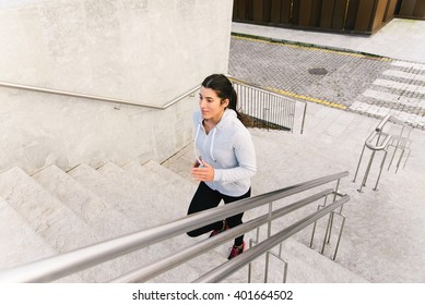 Sporty Urban Woman Running And Climbing Stairs. Female Athlete On Hiit Workout.