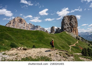 Sporty woman with backpack climbing in Cinque Torri,Dolomites,Italy.Five towers and rock formations close to Cortina d'Ampezzo.Picturesque Dolomite Alps,active summer holiday.Adventure freedom concept