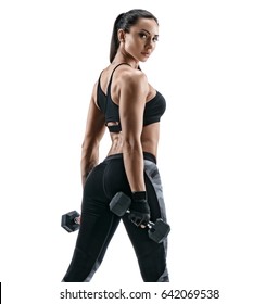 Sporty woman does the exercises with dumbbells on white background. Photo of muscular woman in sportswear on white background. Strength and motivation.