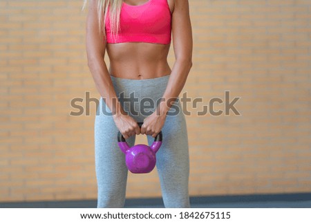 sporty woman doing abdominal exercises with kettlebell dumbbell