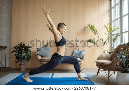 sporty woman doing high lunge yoga exercise at home