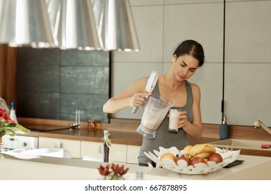 Sporty Woman Drinking Healthy Shake In Kitchen At Home.