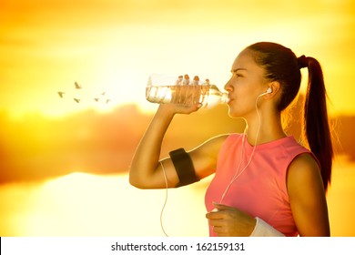 Sporty woman drinking water outdoor on sunny day - Powered by Shutterstock