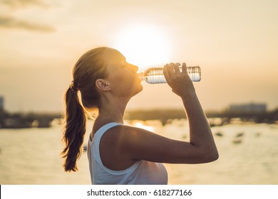 Sporty Woman Drinking Water Outdoor On Sunny Day.