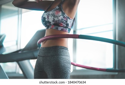 Sporty woman is exercising with Hula hoop in fitness gym for healthy lifestyle concept.