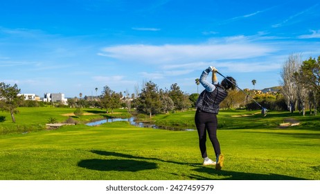 Sporty woman golfer player doing golf swing tee off on the green evening time, she presumably does exercise. Healthy Lifestyle Concept. Healthy Sport. - Powered by Shutterstock