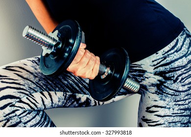 Sporty Woman Holding A Hand Weight In Her Hand In Finland. Focal Point Is Dumbbells And Fingers. Image Includes A Heavy Effect.