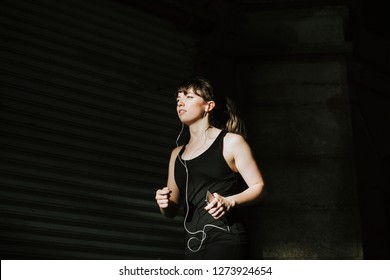 Sporty Woman Jogging In A Dark Alley