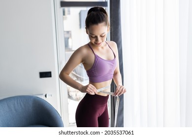 Sporty Woman And Measure Around Her Body At Home.