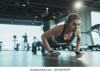 Sporty woman performing push-ups from the floor in the gym. - Powered by Shutterstock