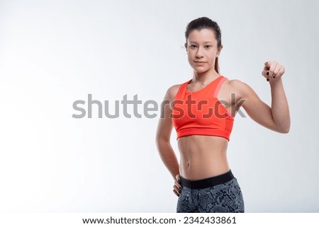 Sporty woman points at you, you're next for fitness transformation. Beauty, fitness personified by her journey. if you don't want fatness do some fitness