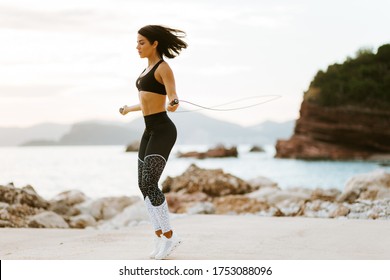 sporty woman skipping rope. Sexy athletic woman rope jumping exercises outdoors on beach. Healthy lifestyle.
