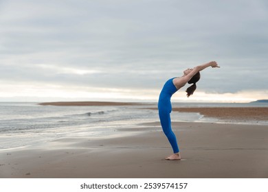 sporty woman standing doing a backbend stretch exercise at the beach, preperation before swimming in the sea. - Powered by Shutterstock