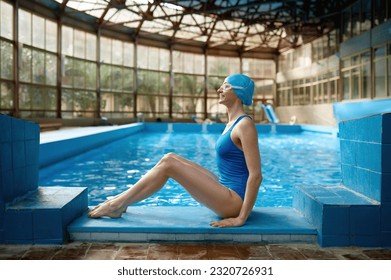 Sporty woman swimmer with perfect slim body sitting at poolside - Powered by Shutterstock