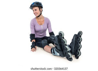 Sporty woman wearing inline skates relaxing over white background