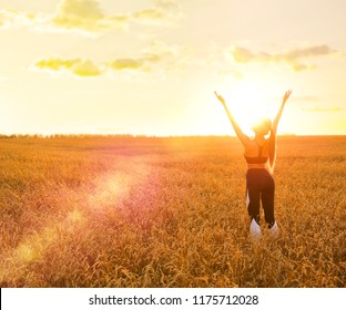 Sporty woman in wheat field at sunset - Shutterstock ID 1175712028