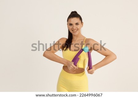 Sporty woman in yellow sport suit doing exercises with breast expander