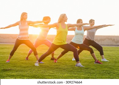 Sporty women warming up during fitness class in parkland - Powered by Shutterstock