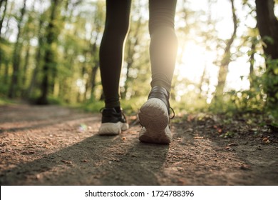 Sporty wooman run in city park at sunset - Shutterstock ID 1724788396