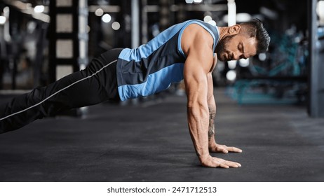 Sporty young man doing pushups in gym, side view, free space - Powered by Shutterstock