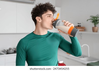 Sporty young man drinking protein shake in kitchen - Powered by Shutterstock