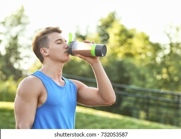 Sporty Young Man Drinking Protein Shake Outdoors